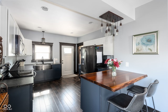 2215 S Delaware St, Indianapolis, IN 46225 - kitchen with a sink, black fridge with ice dispenser, stainless steel microwave, white cabinets, and a peninsula