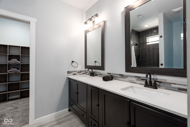 2215 S Delaware St, Indianapolis, IN 46225 - bathroom with double vanity, backsplash, tiled shower, and baseboards