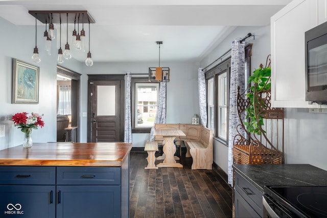 2215 S Delaware St, Indianapolis, IN 46225 - kitchen featuring butcher block counters, blue cabinetry, dark wood-style floors, hanging light fixtures, and black microwave