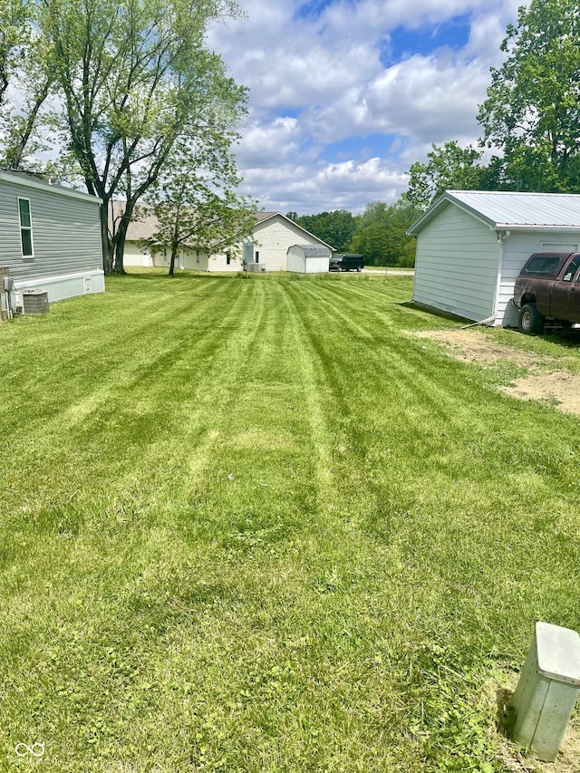 view of grassy yard with central air condition unit
