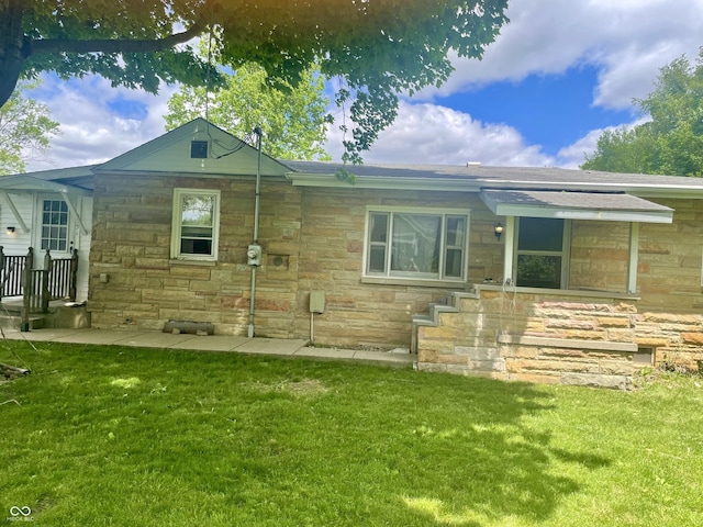 view of front facade featuring stone siding and a front yard