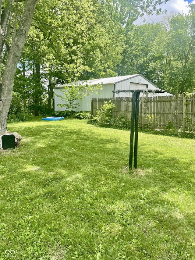 view of yard with a detached garage and an outbuilding