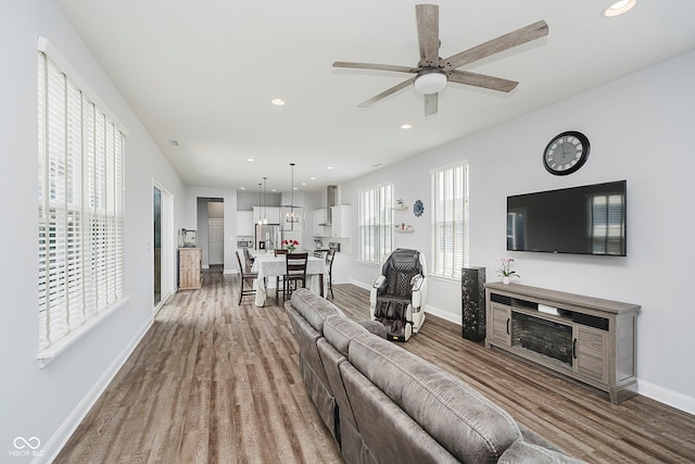 7077 Antiquity Dr, Carmel, IN 46033 - living area with wood finished floors, baseboards, recessed lighting, a ceiling fan, and a fireplace