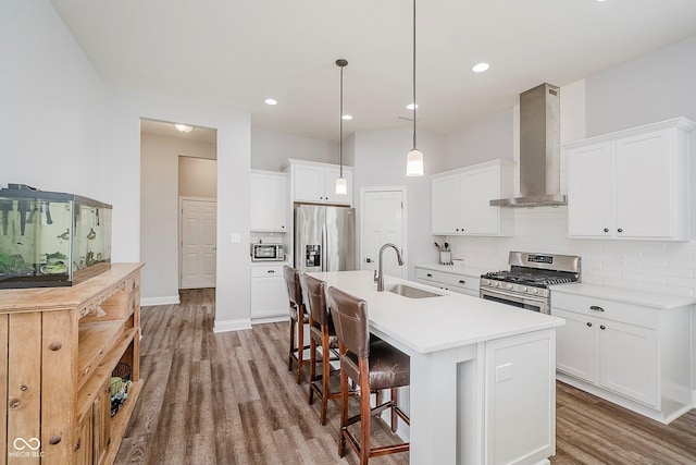 7077 Antiquity Dr, Carmel, IN 46033 - kitchen with appliances with stainless steel finishes, wall chimney exhaust hood, a sink, wood finished floors, and tasteful backsplash