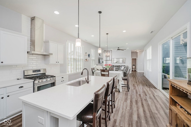 7077 Antiquity Dr, Carmel, IN 46033 - kitchen featuring a sink, wall chimney range hood, stainless steel gas range, plenty of natural light, and recessed lighting