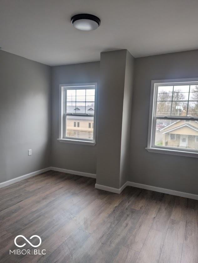 2968 N Arsenal Ave, Indianapolis, IN 46218 - spare room with wood finished floors, healthy amount of natural light, and baseboards