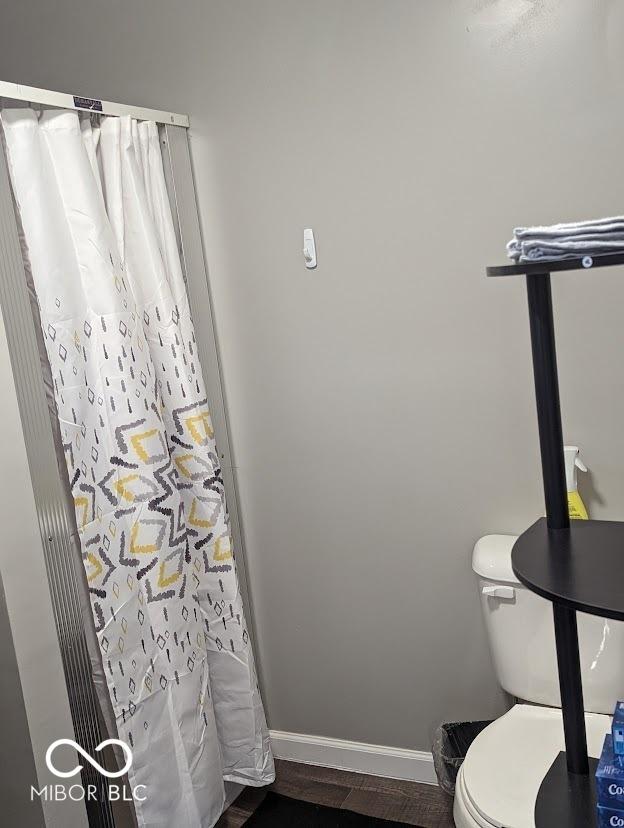 2968 N Arsenal Ave, Indianapolis, IN 46218 - bathroom with baseboards, toilet, wood finished floors, and a shower with shower curtain