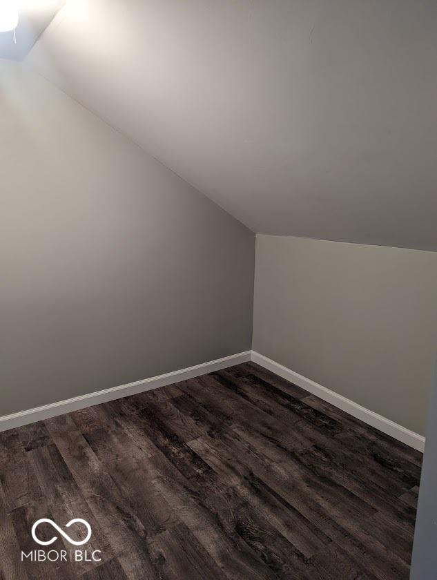2968 N Arsenal Ave, Indianapolis, IN 46218 - additional living space with vaulted ceiling, dark wood-type flooring, and baseboards