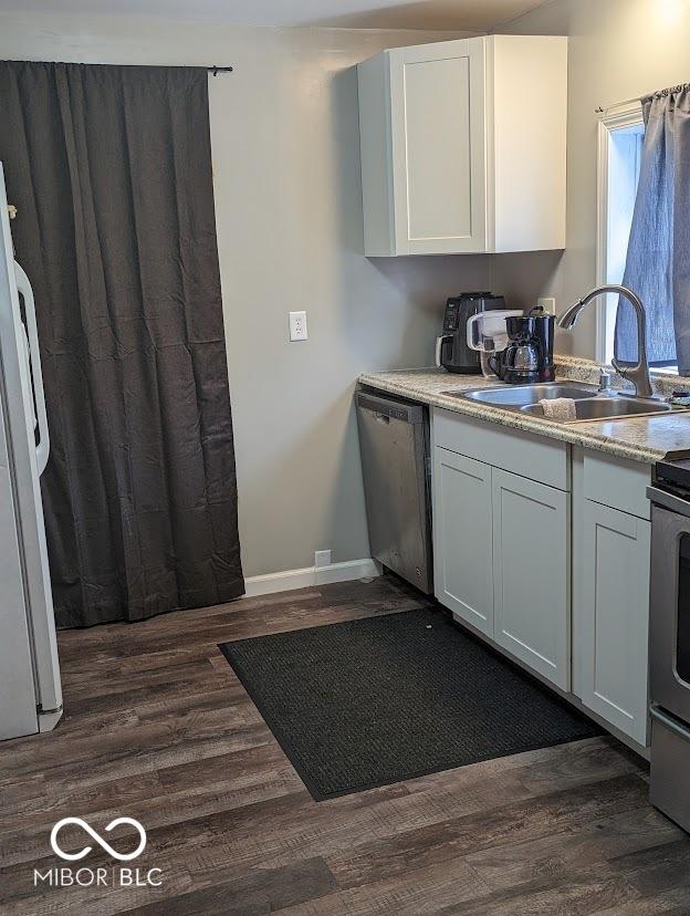 2968 N Arsenal Ave, Indianapolis, IN 46218 - kitchen with a sink, dishwasher, dark wood-style flooring, white cabinets, and range