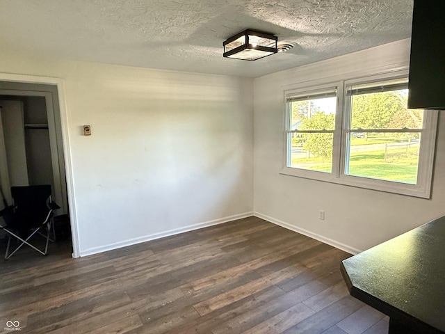 1328 N 300 E, Anderson, IN 46012 - unfurnished dining area featuring dark wood-type flooring, baseboards, and a textured ceiling