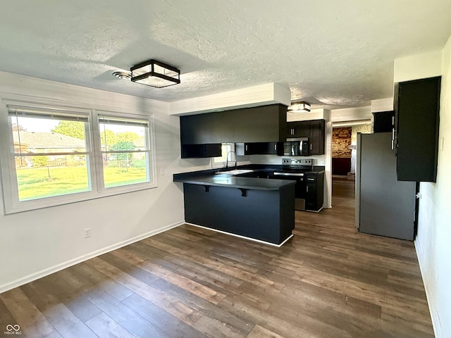 1328 N 300 E, Anderson, IN 46012 - kitchen with freestanding refrigerator, range with electric stovetop, a peninsula, a sink, and dark cabinetry