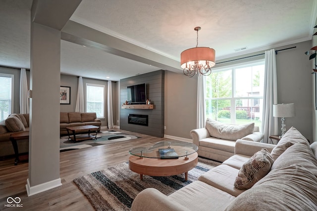 548 Gosford Ct, Westfield, IN 46074 - living area featuring a fireplace, ornamental molding, plenty of natural light, a chandelier, and a textured ceiling
