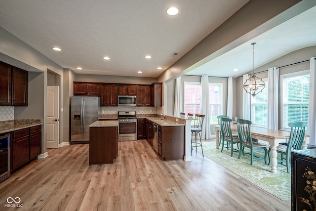 548 Gosford Ct, Westfield, IN 46074 - kitchen featuring appliances with stainless steel finishes, light wood-style flooring, decorative backsplash, light stone countertops, and recessed lighting