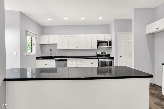 7513 Pine Royal Dr, Indianapolis, IN 46256 - kitchen featuring stainless steel appliances, dark countertops, white cabinetry, and recessed lighting