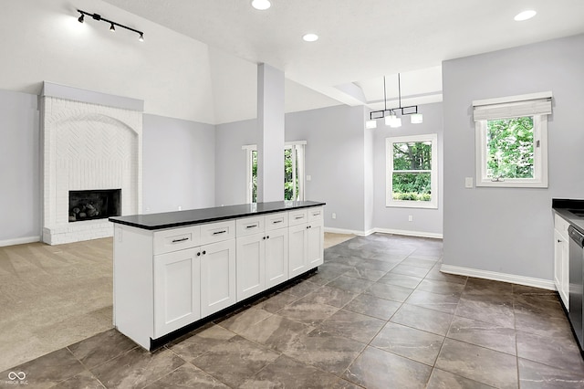 7513 Pine Royal Dr, Indianapolis, IN 46256 - kitchen featuring dark countertops, white cabinetry, a brick fireplace, a center island, and open floor plan