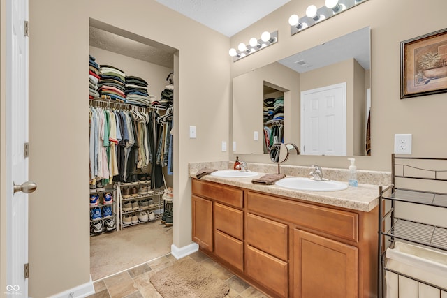 10731 Jimmy Lake Dr, Indianapolis, IN 46239 - full bath featuring double vanity, a spacious closet, stone finish floors, and baseboards