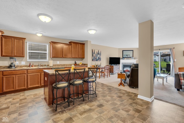 10731 Jimmy Lake Dr, Indianapolis, IN 46239 - kitchen with brown cabinets, a breakfast bar area, light stone counters, a kitchen island, and open floor plan