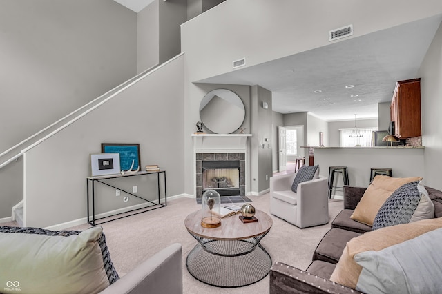 1064 Reserve Way, Indianapolis, IN 46220 - living area featuring light colored carpet, a tile fireplace, baseboards, and stairway