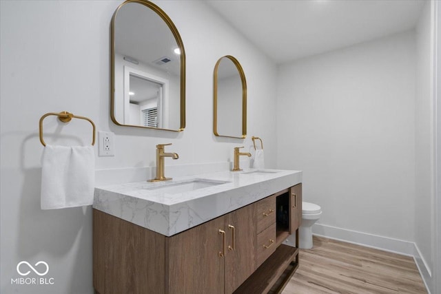 450 Historic Pleasant St, Noblesville, IN 46060 - bathroom featuring double vanity, toilet, wood finished floors, and baseboards