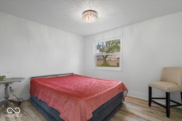 450 Historic Pleasant St, Noblesville, IN 46060 - bedroom with wood finished floors, a chandelier, and baseboards