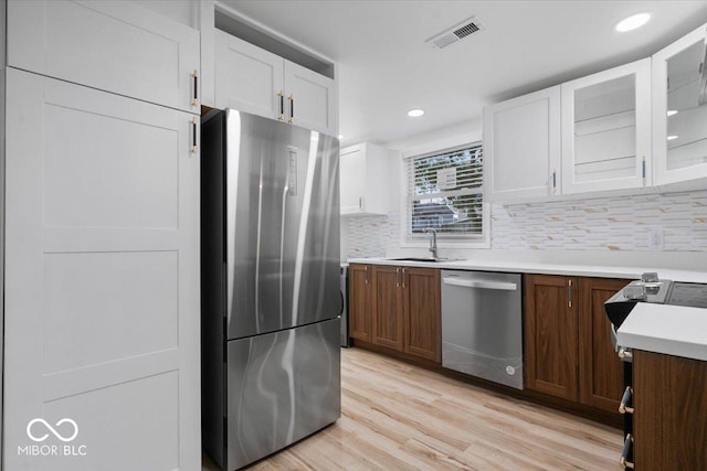 450 Historic Pleasant St, Noblesville, IN 46060 - kitchen with appliances with stainless steel finishes, a sink, white cabinets, light countertops, and backsplash