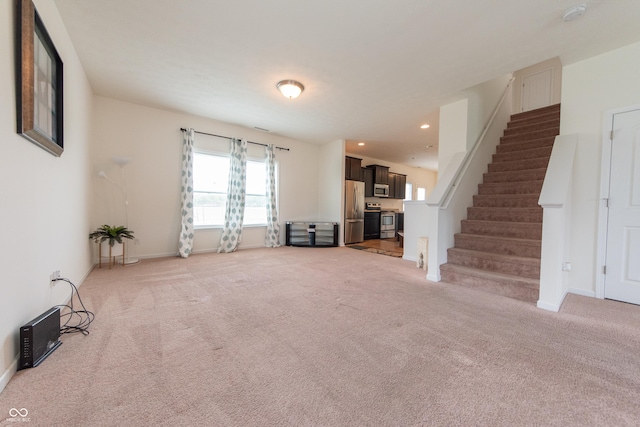 4712 Clairmont Dr, Columbus, IN 47203 - unfurnished living room featuring stairs, light carpet, baseboards, and recessed lighting
