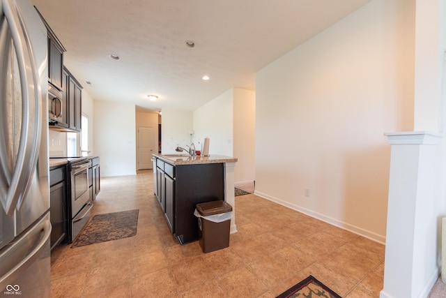 4712 Clairmont Dr, Columbus, IN 47203 - kitchen with stainless steel appliances, a center island with sink, a sink, recessed lighting, and light stone countertops