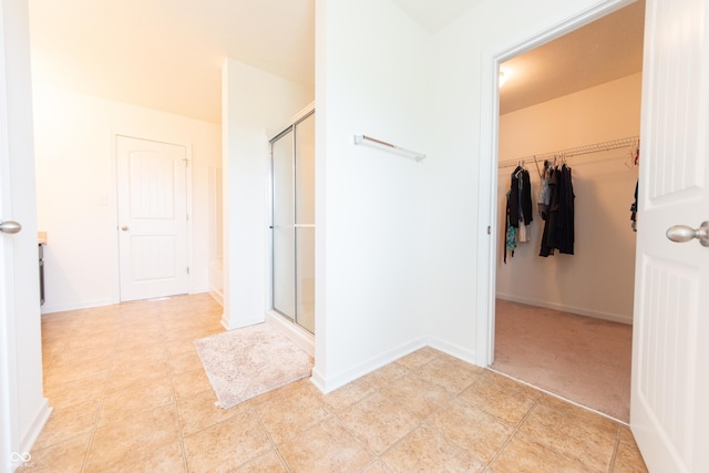 4712 Clairmont Dr, Columbus, IN 47203 - bathroom with a stall shower, a walk in closet, baseboards, and tile patterned floors
