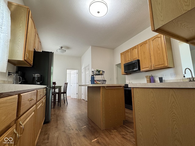 7970 Cobblesprings Dr, Avon, IN 46123 - kitchen with dark wood finished floors, light countertops, a sink, and freestanding refrigerator