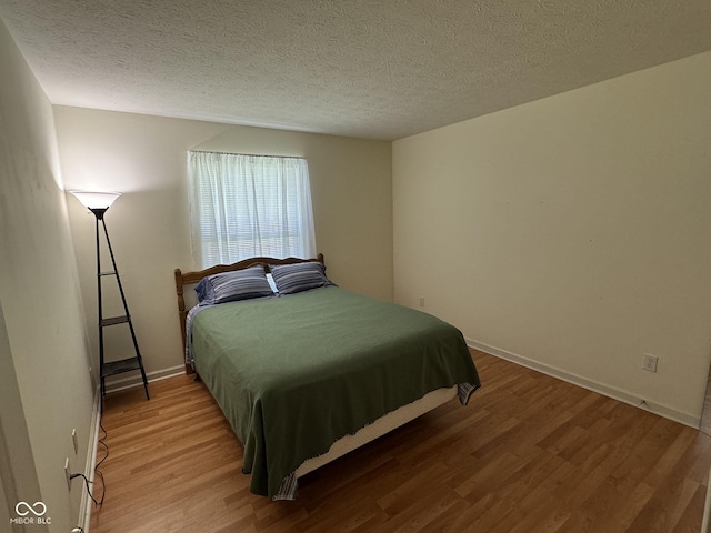 7970 Cobblesprings Dr, Avon, IN 46123 - bedroom featuring wood finished floors, baseboards, and a textured ceiling