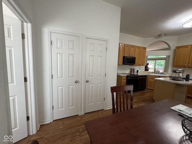 7970 Cobblesprings Dr, Avon, IN 46123 - kitchen featuring black appliances, light countertops, dark wood finished floors, a textured ceiling, and a sink