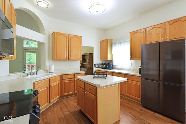 7970 Cobblesprings Dr, Avon, IN 46123 - kitchen with freestanding refrigerator, range, wood finished floors, light countertops, and a center island