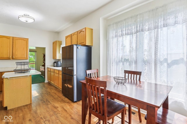 7970 Cobblesprings Dr, Avon, IN 46123 - kitchen featuring freestanding refrigerator, light countertops, light wood-style flooring, and a center island