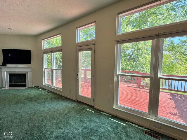 7970 Cobblesprings Dr, Avon, IN 46123 - doorway to outside featuring carpet floors, a fireplace with flush hearth, a textured ceiling, and baseboards