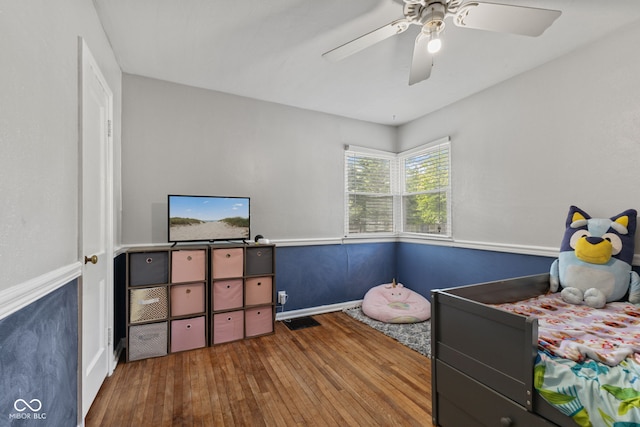 bedroom with hardwood / wood-style flooring, ceiling fan, and baseboards