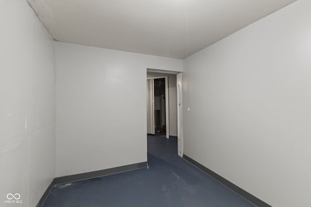 spare room featuring baseboards and finished concrete floors