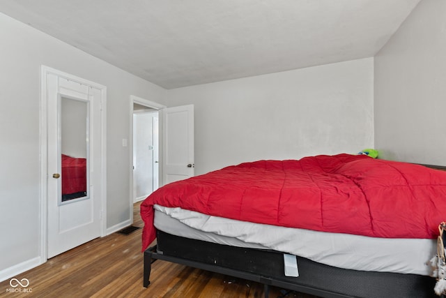 bedroom with wood finished floors and baseboards
