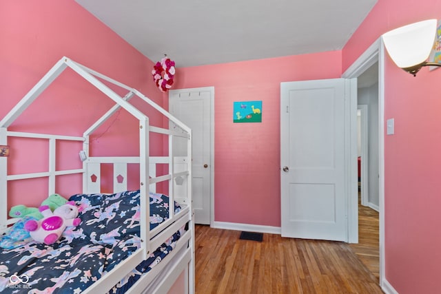 bedroom with wood finished floors and baseboards