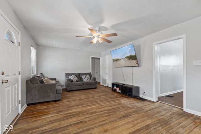 living room with wood-type flooring, ceiling fan, and baseboards