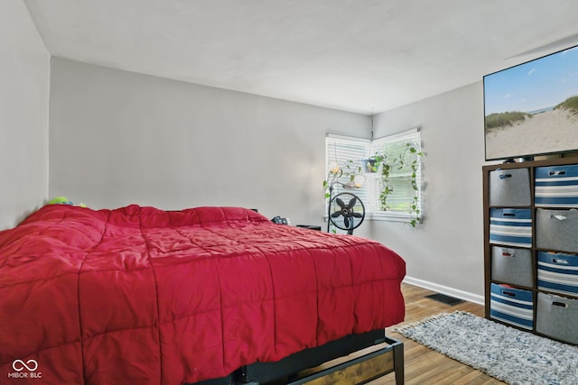 bedroom with wood finished floors and baseboards