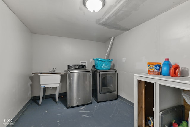 washroom with washing machine and clothes dryer and baseboards