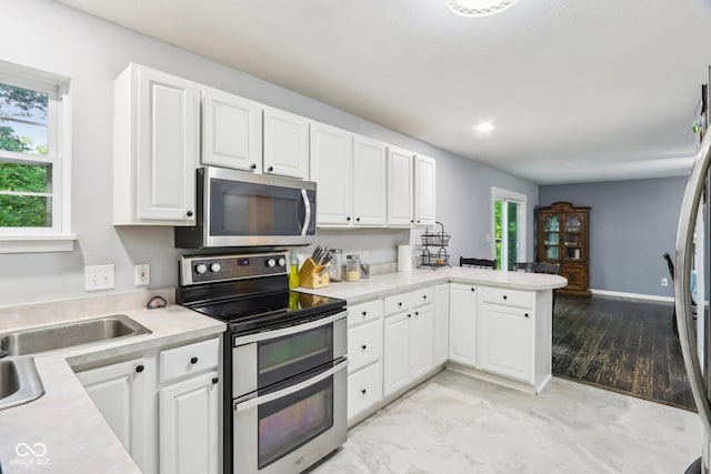 6804 Erika Ln, Nashville, IN 47448 - kitchen featuring appliances with stainless steel finishes, light countertops, white cabinets, a peninsula, and recessed lighting