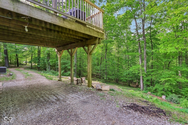 6804 Erika Ln, Nashville, IN 47448 - view of yard featuring driveway, a wooden deck, a view of trees, central air condition unit, and a carport