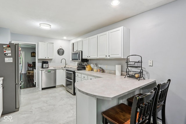 6804 Erika Ln, Nashville, IN 47448 - kitchen with stainless steel appliances, a peninsula, a sink, light marble finish flooring, and light countertops