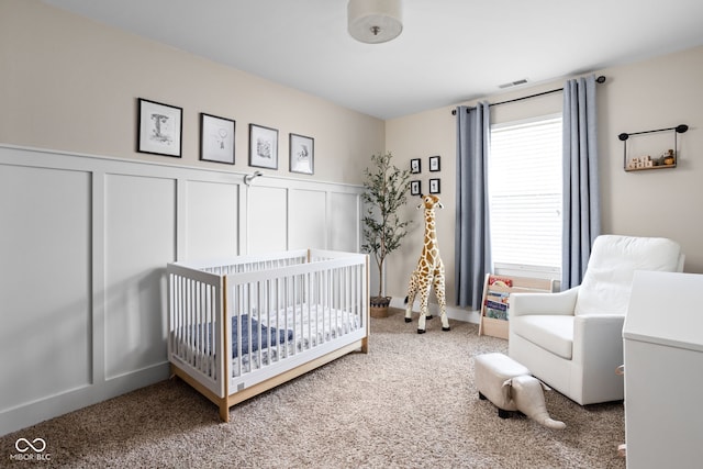 609 E 39th St, Indianapolis, IN 46205 - bedroom with a decorative wall, carpet, a nursery area, and a wainscoted wall