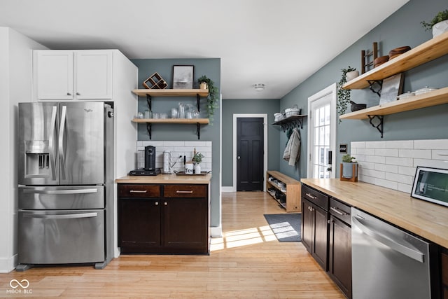 609 E 39th St, Indianapolis, IN 46205 - kitchen featuring appliances with stainless steel finishes, open shelves, tasteful backsplash, and light wood-style floors