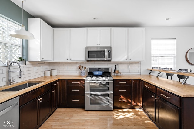 609 E 39th St, Indianapolis, IN 46205 - kitchen featuring stainless steel appliances, white cabinetry, light wood-style flooring, and recessed lighting