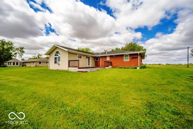17310 N Willman Rd, Eaton, IN 47338 - rear view of property featuring a wooden deck, a lawn, and brick siding