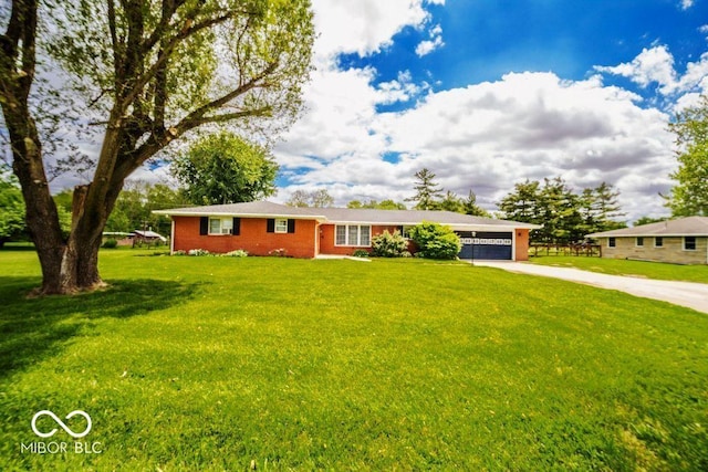 17310 N Willman Rd, Eaton, IN 47338 - ranch-style home with concrete driveway, a garage, brick siding, and a front yard