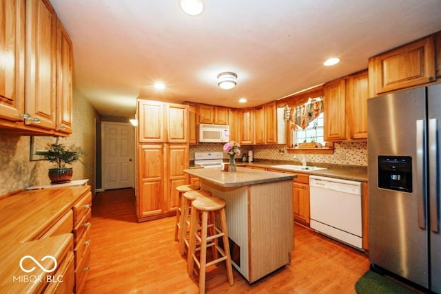 17310 N Willman Rd, Eaton, IN 47338 - kitchen featuring white appliances, a sink, light wood-style flooring, a kitchen bar, and a center island